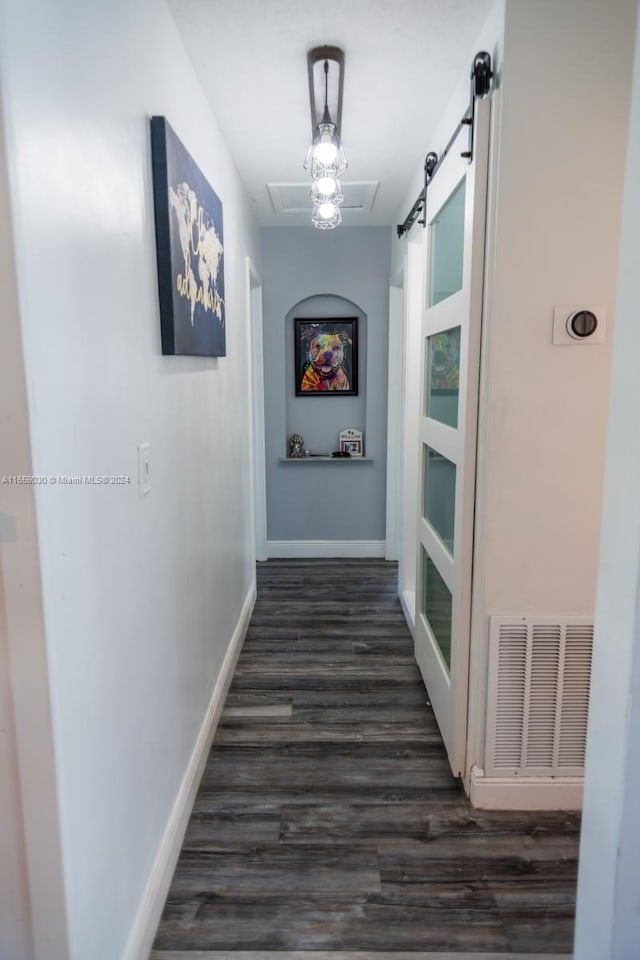 hall featuring a barn door and dark hardwood / wood-style floors