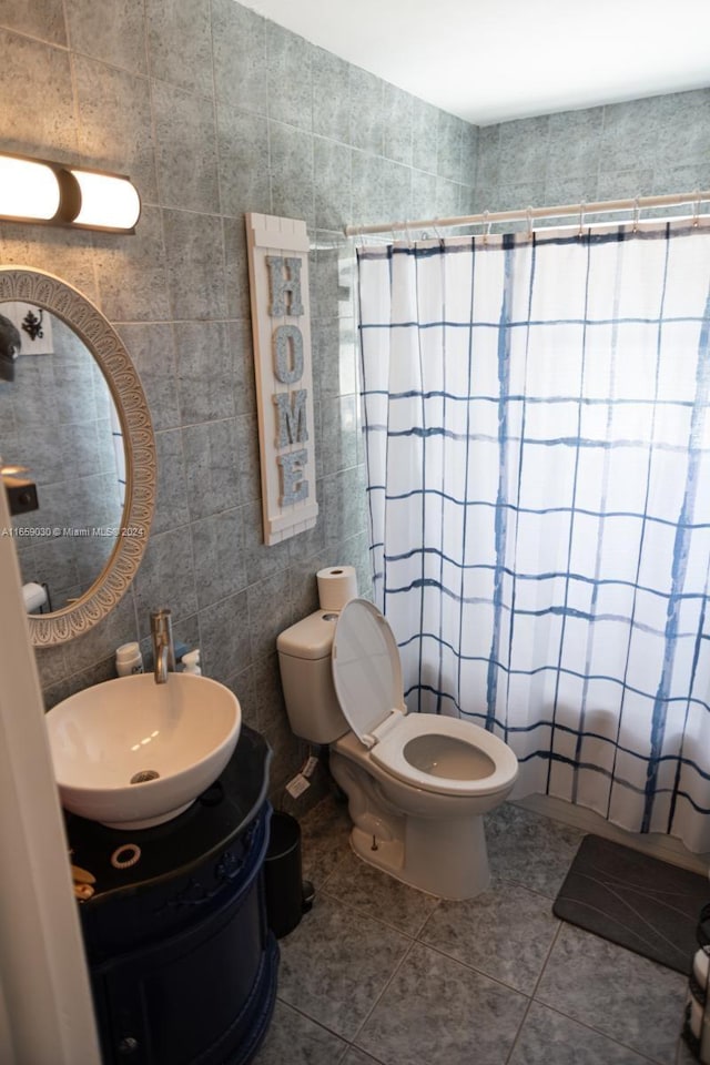 bathroom with tile patterned flooring, tile walls, toilet, and vanity