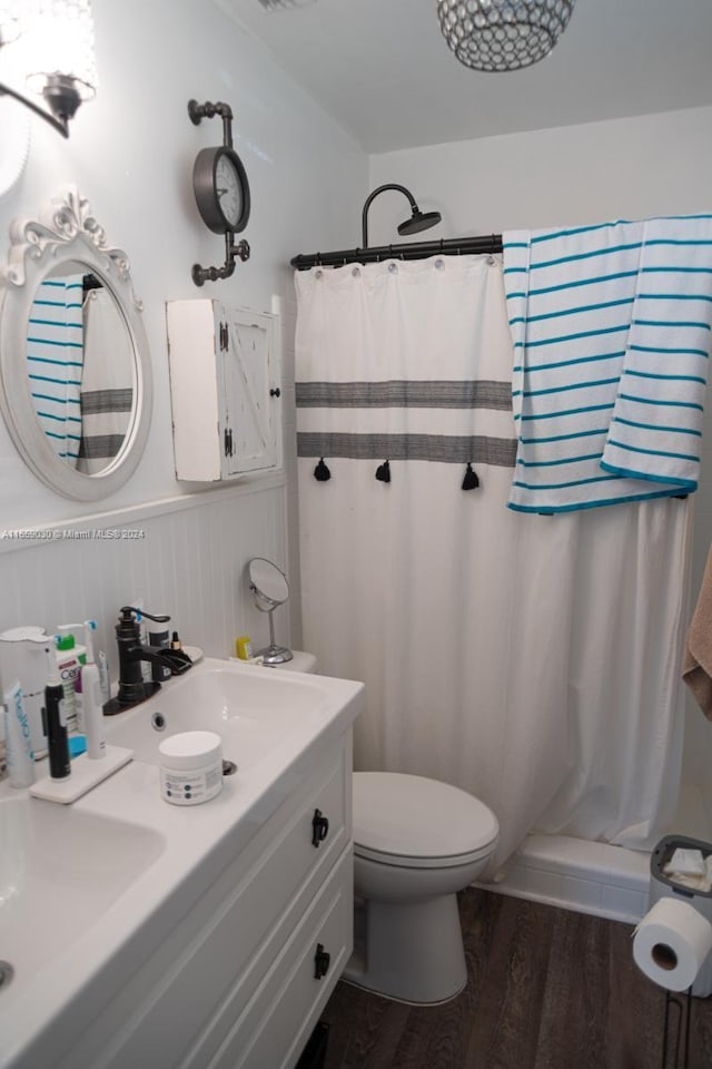 bathroom featuring curtained shower, toilet, hardwood / wood-style flooring, and vanity