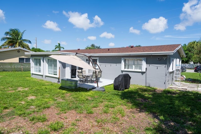 back of property featuring a lawn and a patio