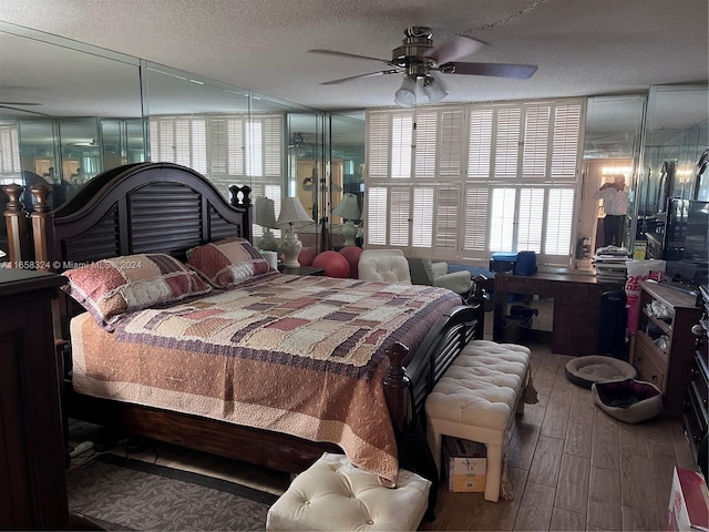 bedroom with wood-type flooring, a textured ceiling, and ceiling fan