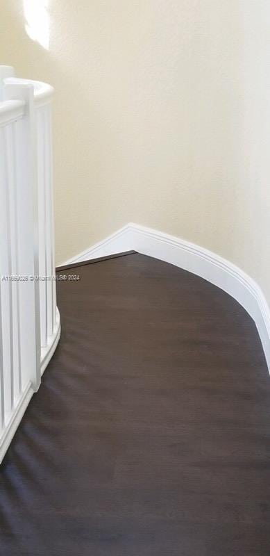 unfurnished room with dark wood-type flooring