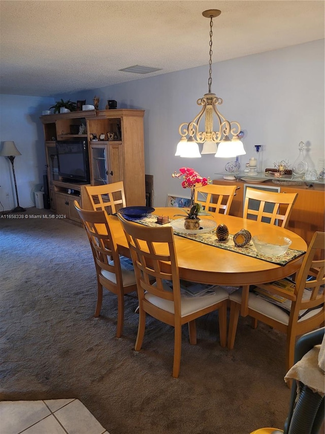 carpeted dining room featuring a textured ceiling and a notable chandelier