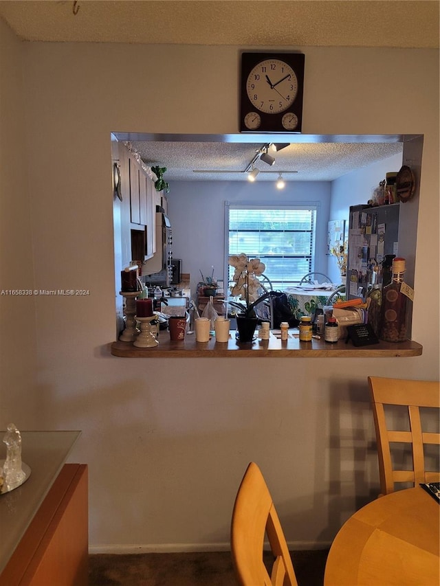 kitchen with track lighting, refrigerator, and a textured ceiling