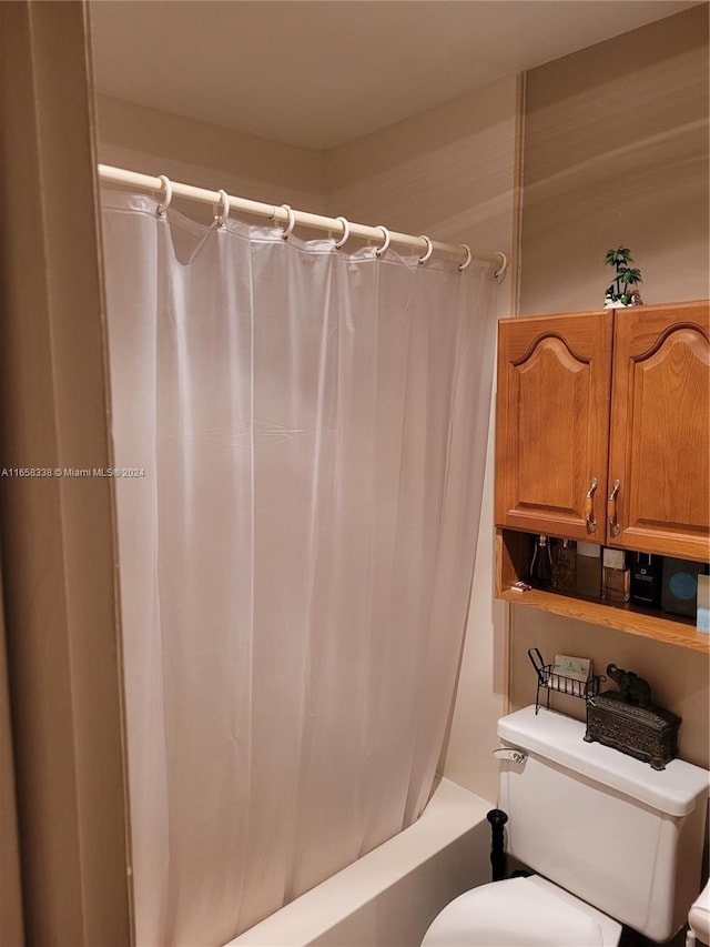 bathroom with toilet and shower / tub combo with curtain