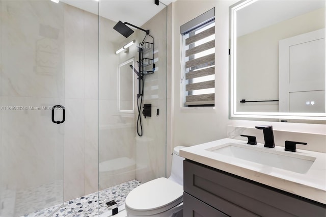 bathroom with vanity, toilet, and a shower with shower door