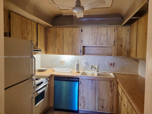 kitchen with under cabinet range hood, stove, a sink, stainless steel dishwasher, and freestanding refrigerator