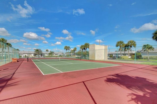 view of tennis court featuring community basketball court and fence