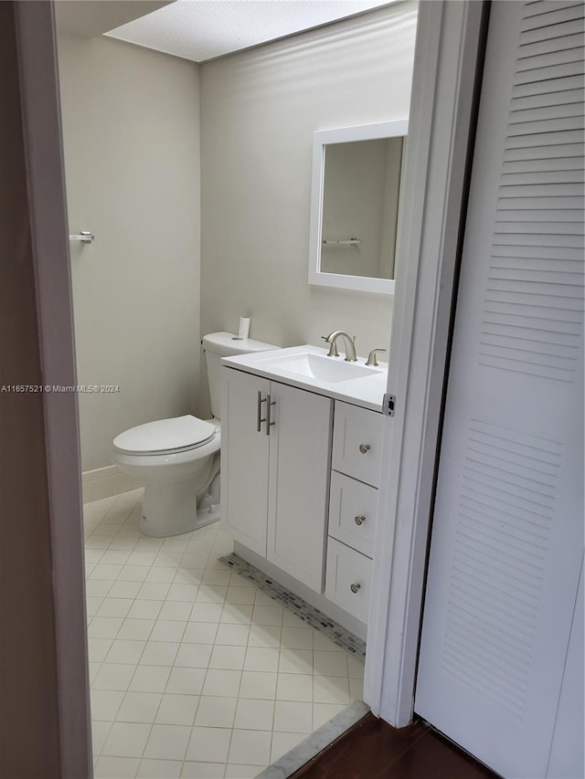 bathroom with tile patterned flooring, vanity, and toilet