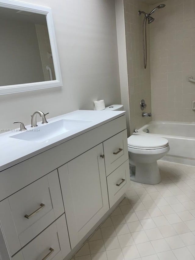 full bathroom featuring vanity, tiled shower / bath combo, and toilet