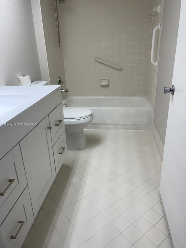 full bathroom featuring tiled shower / bath, vanity, tile patterned flooring, and toilet