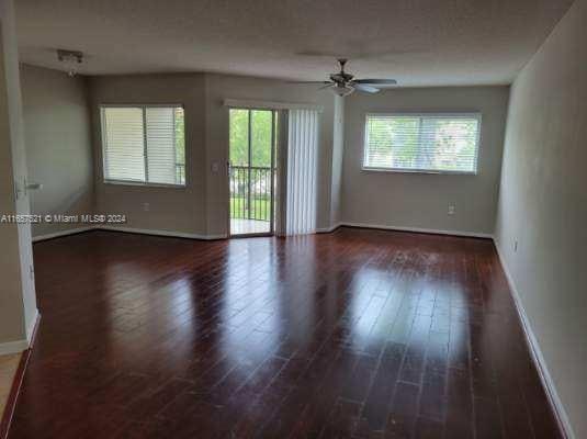 empty room with ceiling fan and dark hardwood / wood-style floors