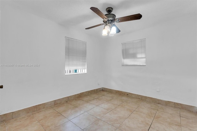 spare room with ceiling fan and light tile patterned floors