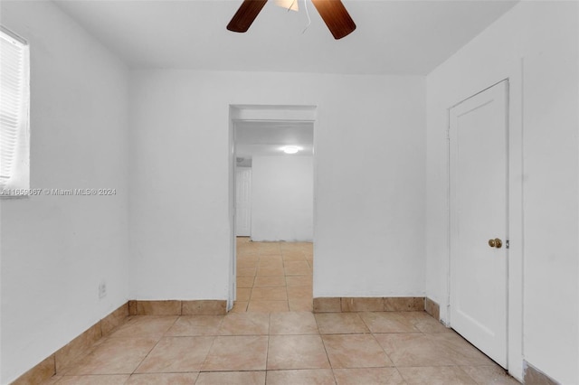 empty room with ceiling fan and light tile patterned floors