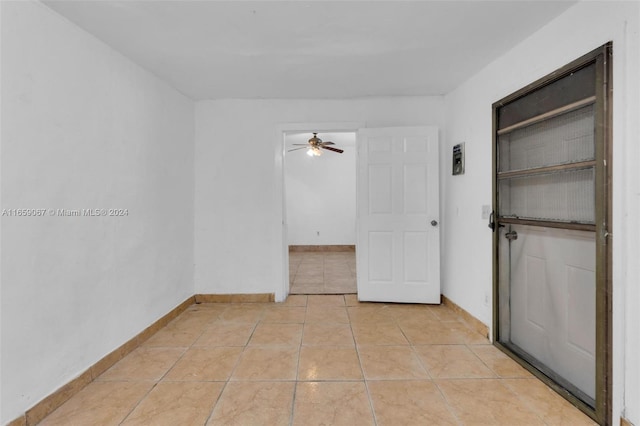 tiled spare room with ceiling fan