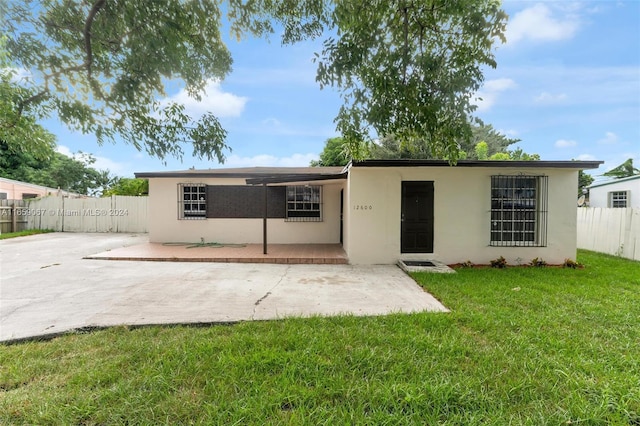 rear view of house featuring a patio area and a lawn