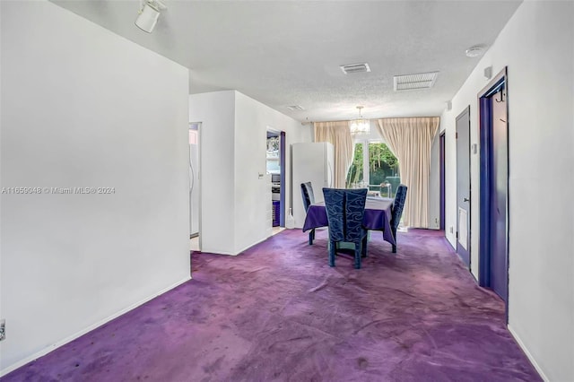 carpeted dining space featuring a textured ceiling