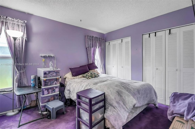 carpeted bedroom with multiple closets and a textured ceiling