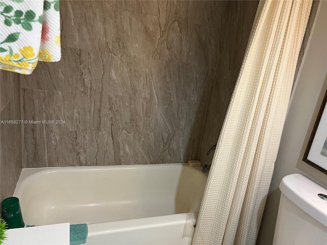 bathroom with toilet and shower / tub combo with curtain