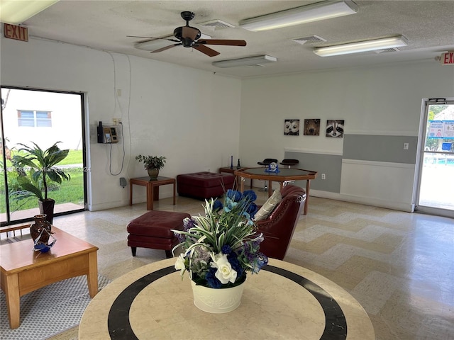 living room with a textured ceiling and ceiling fan