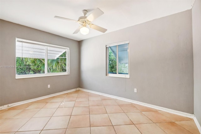 tiled spare room with ceiling fan