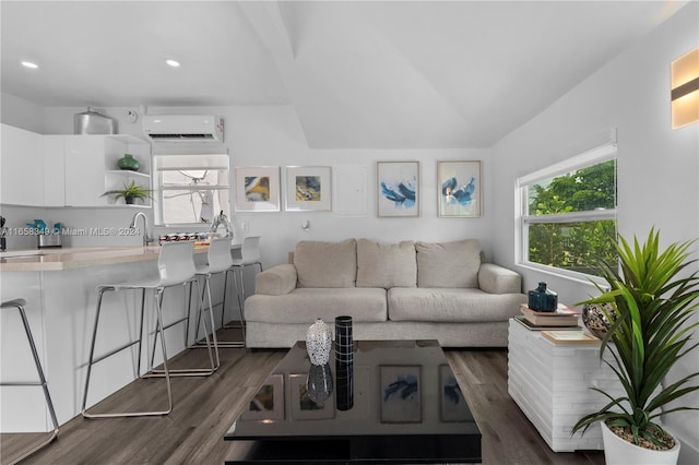 living room with dark hardwood / wood-style flooring, an AC wall unit, sink, and lofted ceiling