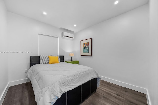 bedroom with a wall mounted AC and dark hardwood / wood-style floors