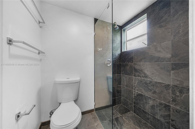 bathroom with toilet and a tile shower