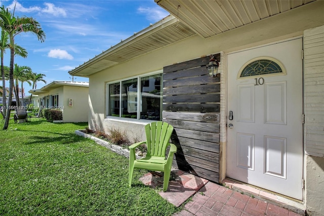 property entrance with a lawn