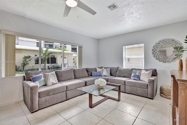 living room with light tile patterned floors, ceiling fan, and a wealth of natural light