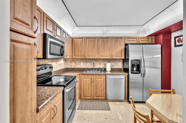 kitchen with appliances with stainless steel finishes, backsplash, and sink