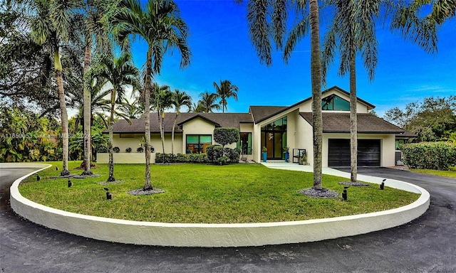 single story home featuring a front yard and a garage