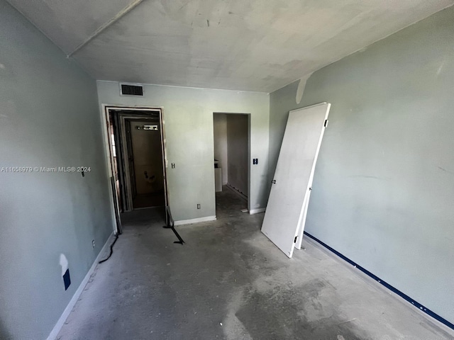 unfurnished bedroom with concrete floors