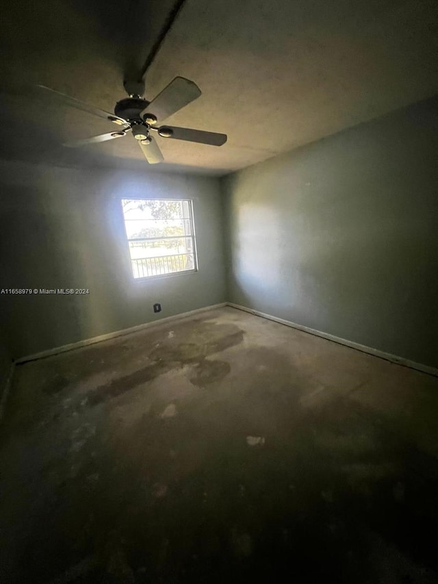 spare room featuring ceiling fan and concrete floors