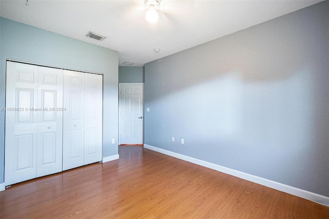 unfurnished bedroom featuring hardwood / wood-style flooring and a closet