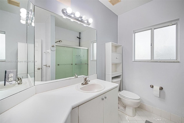 bathroom featuring tile patterned floors, toilet, a shower with door, and vanity