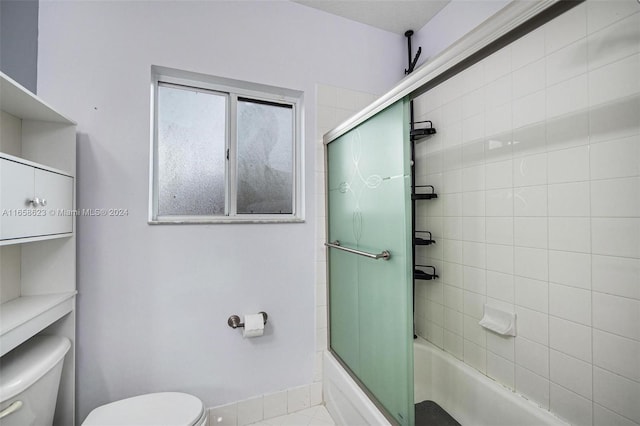 bathroom with enclosed tub / shower combo, toilet, and tile patterned floors