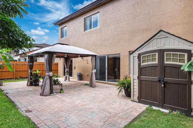 rear view of property featuring a patio area and a gazebo