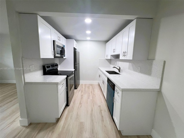 kitchen featuring sink, white cabinetry, light hardwood / wood-style flooring, and stainless steel appliances