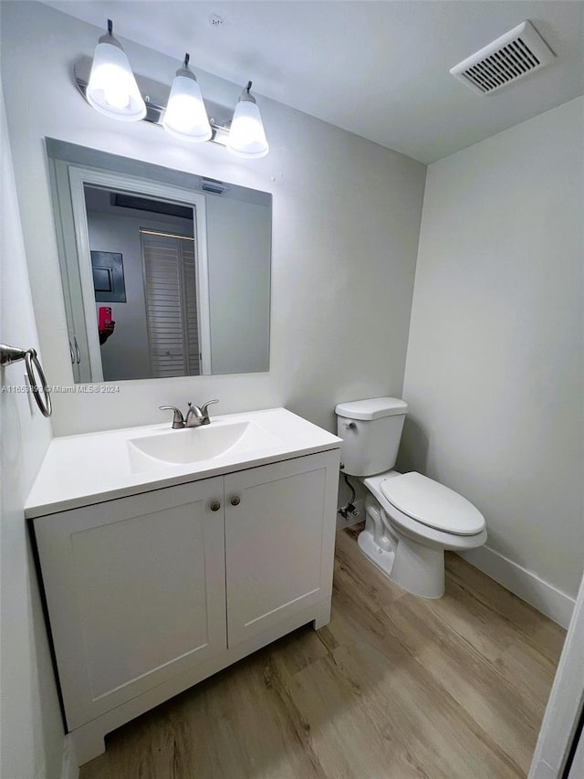 bathroom featuring vanity, hardwood / wood-style flooring, and toilet