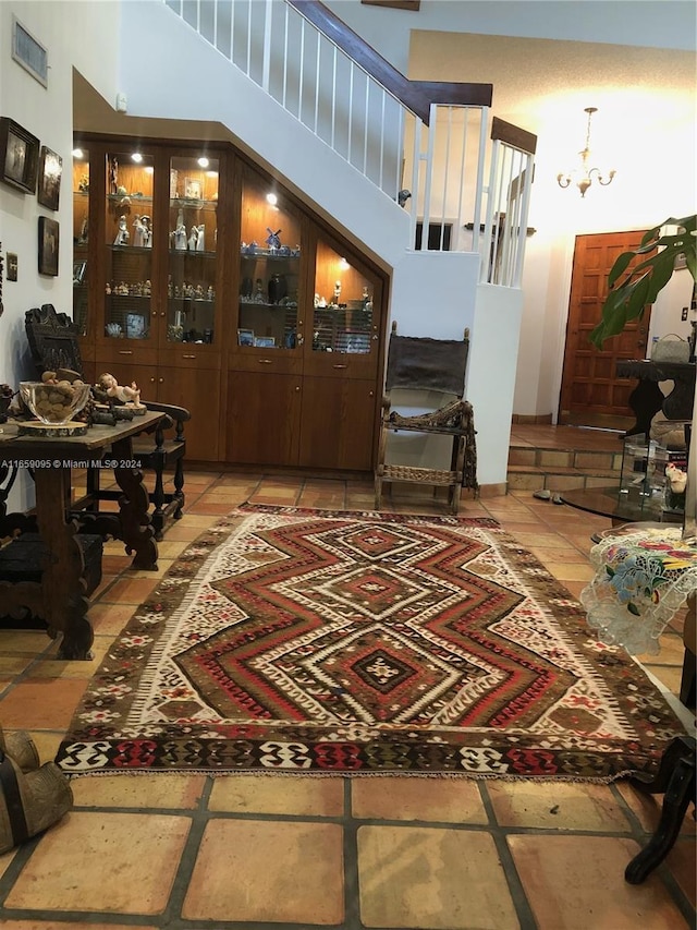 living room with a chandelier and a towering ceiling