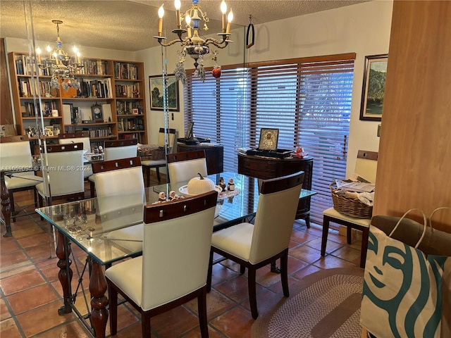 dining area with tile patterned floors, a notable chandelier, and a textured ceiling