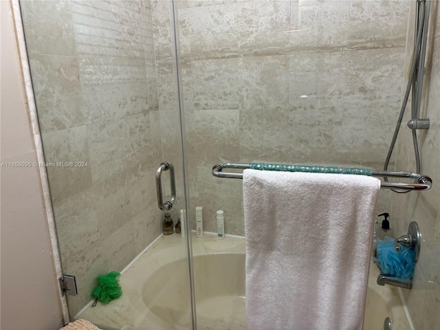 bathroom featuring bath / shower combo with glass door