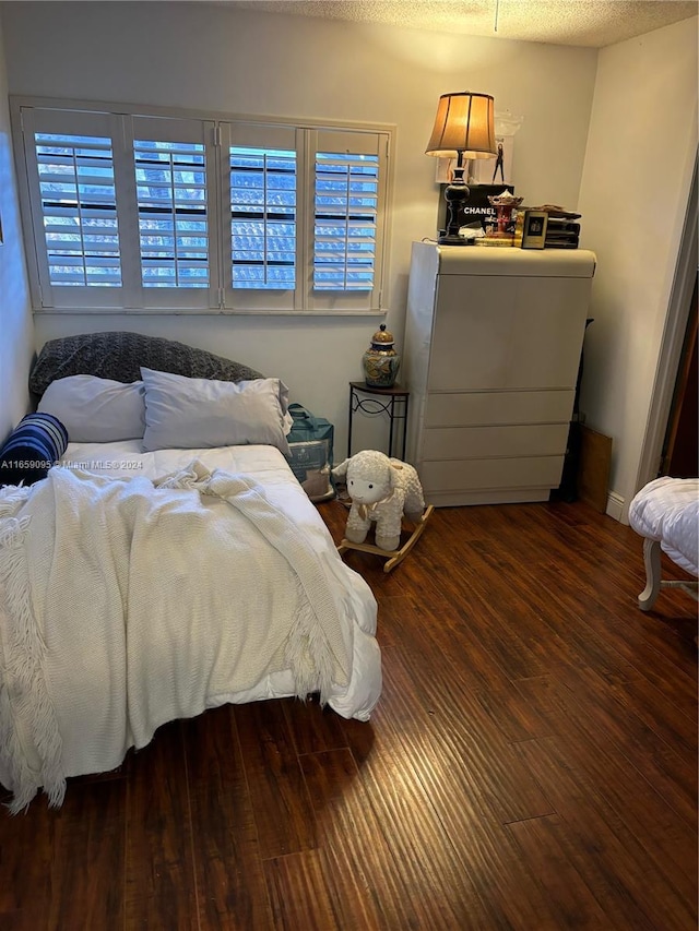 bedroom featuring hardwood / wood-style floors and a textured ceiling