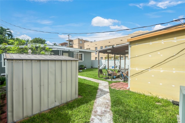 view of yard with a storage unit and a patio