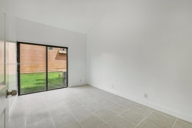 unfurnished room featuring vaulted ceiling and light tile patterned flooring