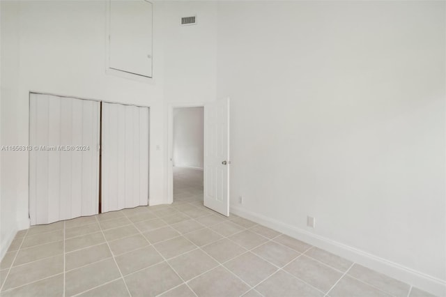 unfurnished bedroom with a closet, light tile patterned floors, baseboards, and visible vents