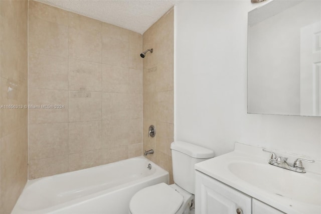 full bathroom with tiled shower / bath combo, vanity, toilet, and a textured ceiling