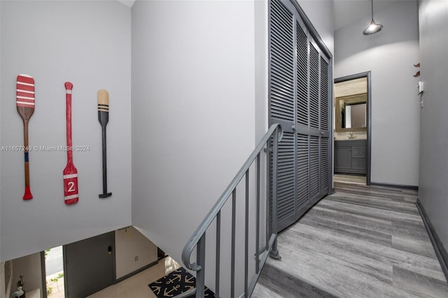 staircase featuring a towering ceiling and hardwood / wood-style floors