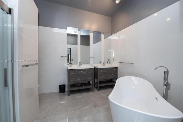 bathroom with vanity, tile walls, and a bathing tub